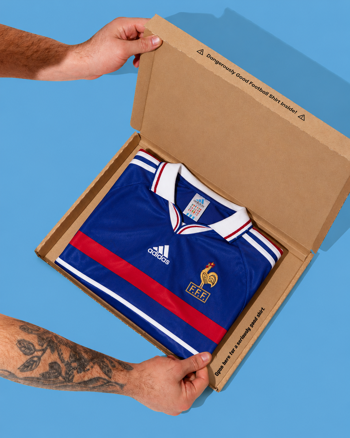 Handen die een retro shirt uit de mystery box halen